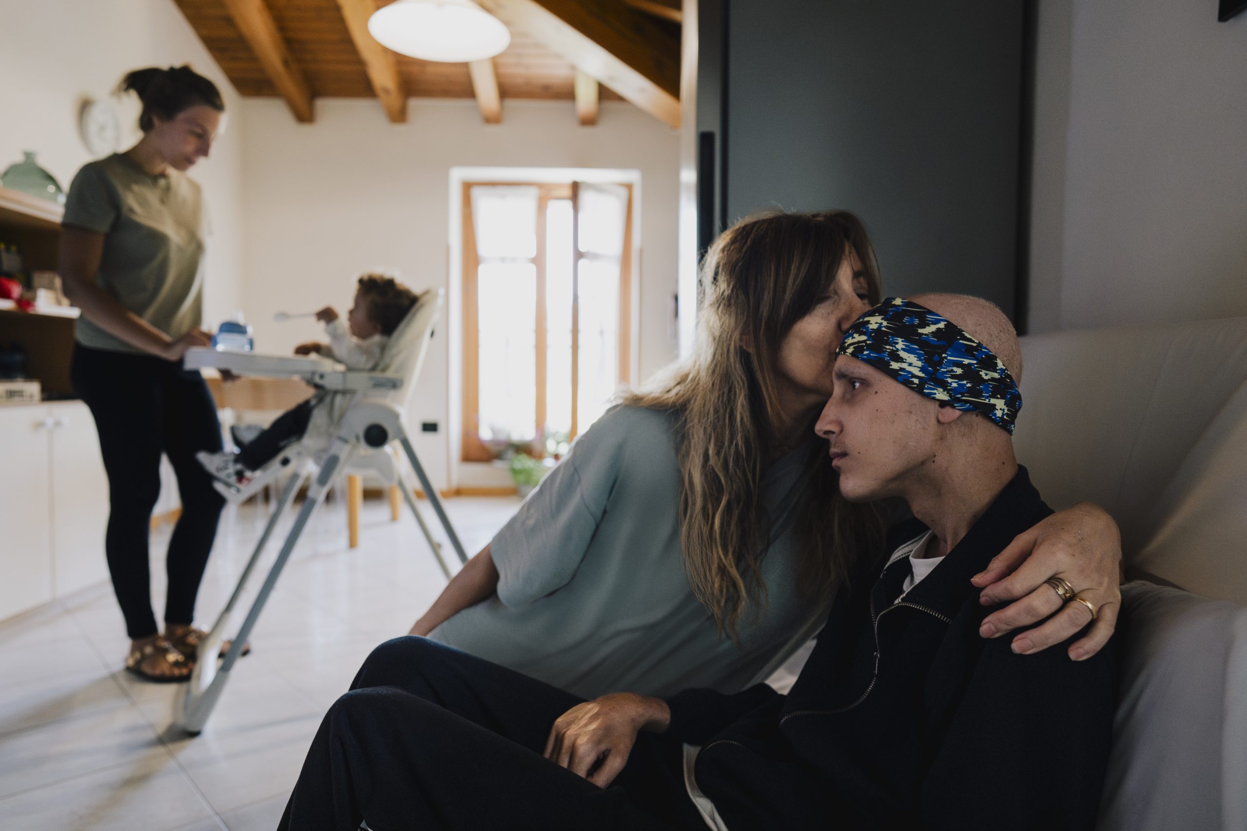 Madre che dà un bacio al figlio seduti sul divano