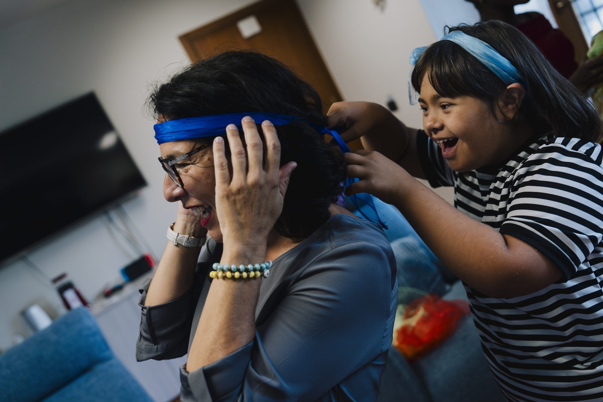 Bambina che allaccia un nastro intorno alla testa della madre