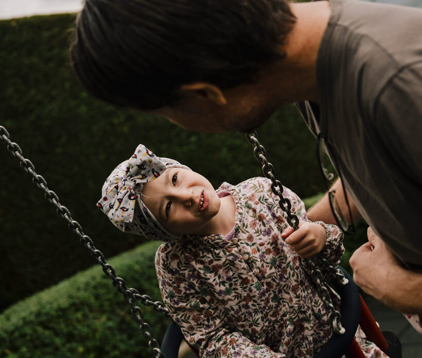 Bambina sull'altalena con il padre
