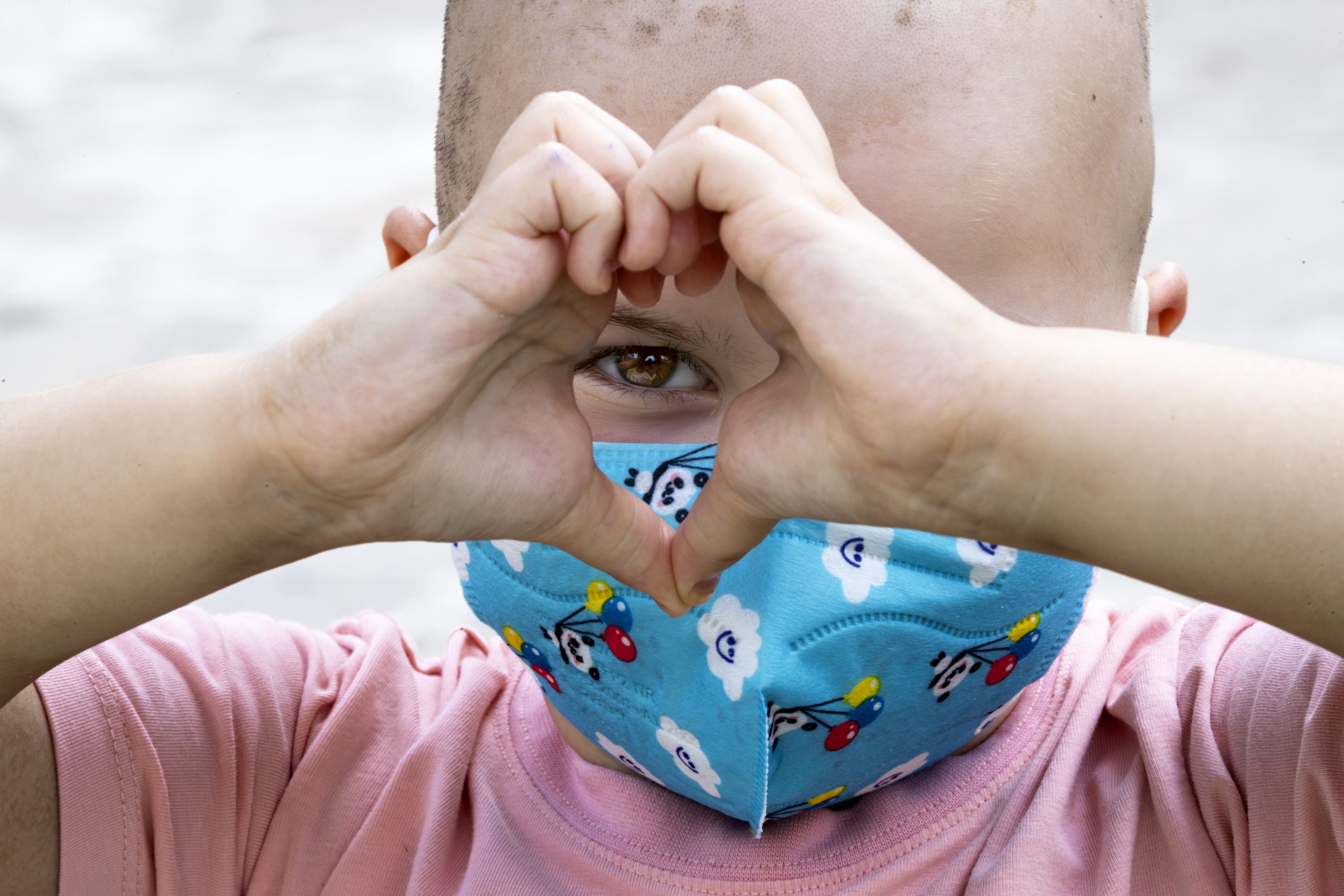 Bambino che disegna un cuore con le mani