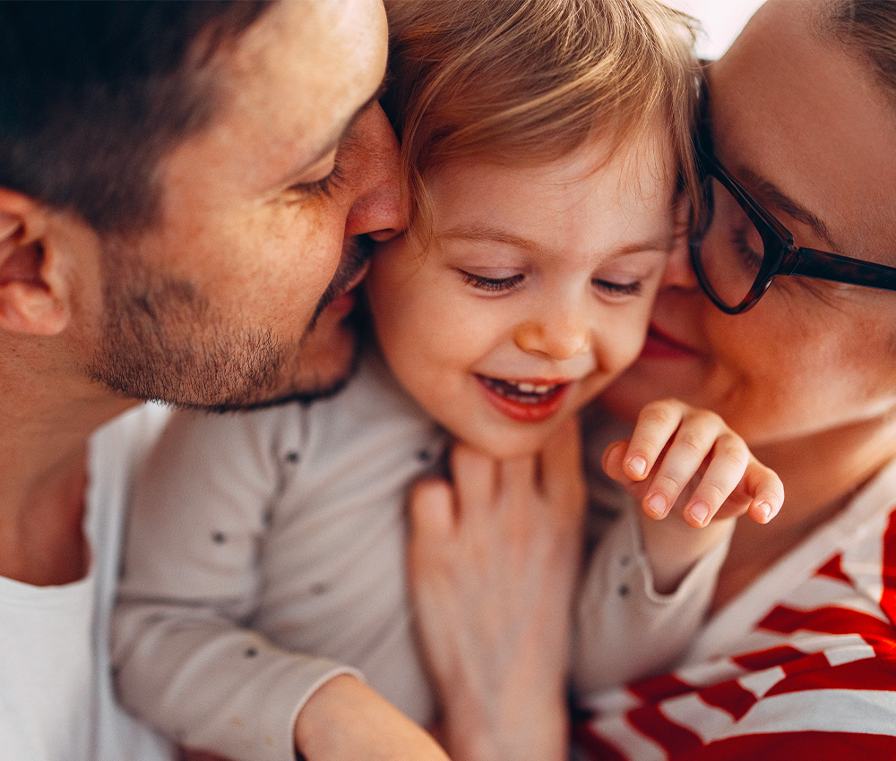 Parents hugging their child