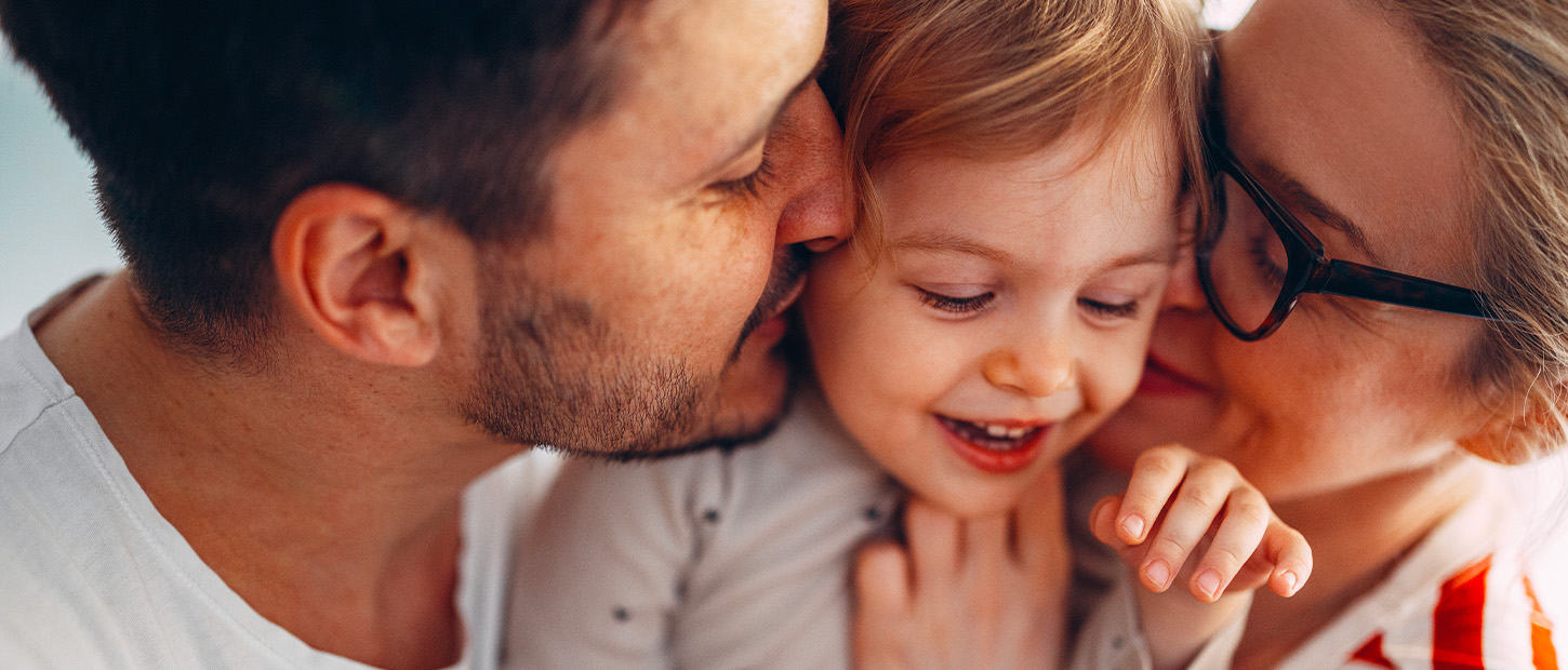 Parents hugging their child