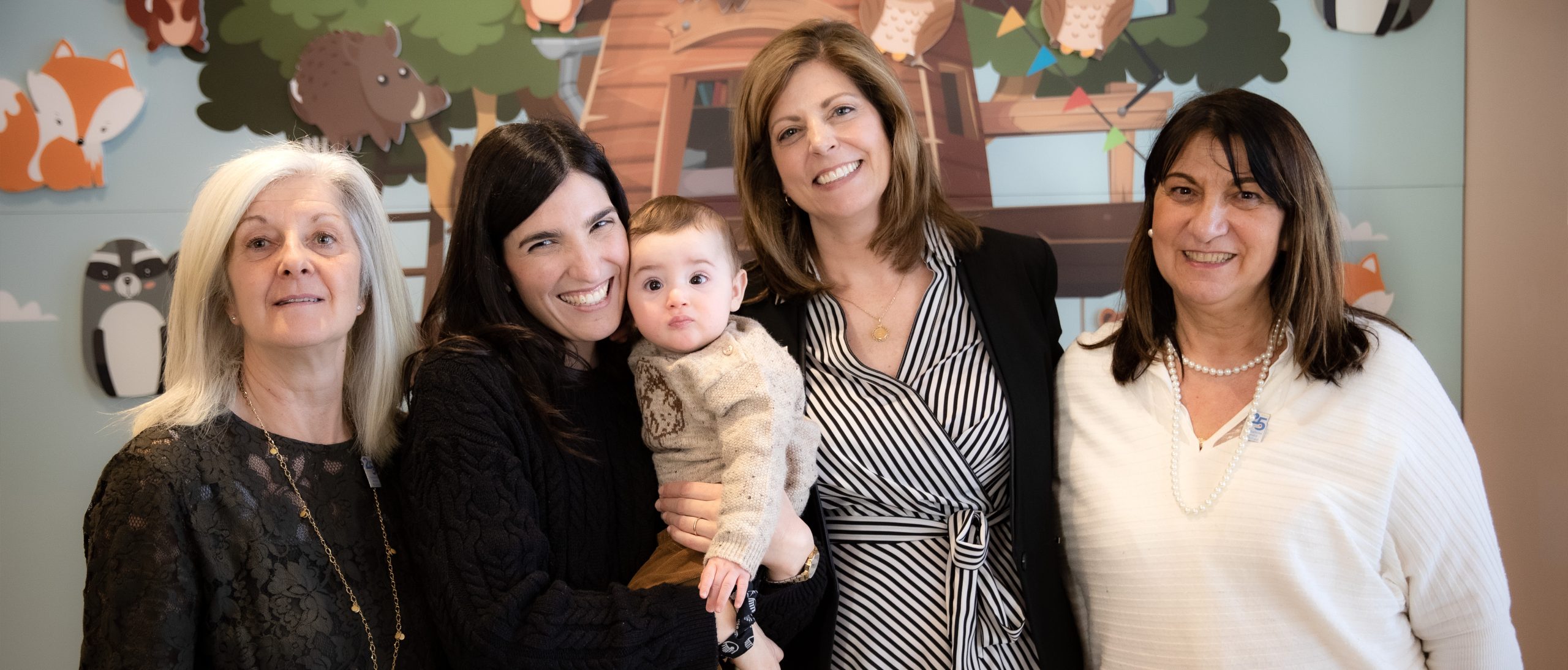 Foto di gruppo con quattro donne e una bambina in braccio