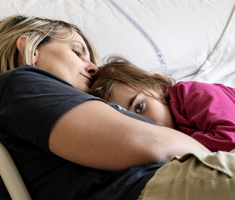 Madre e bambina si riposano insieme su un letto d’ospedale