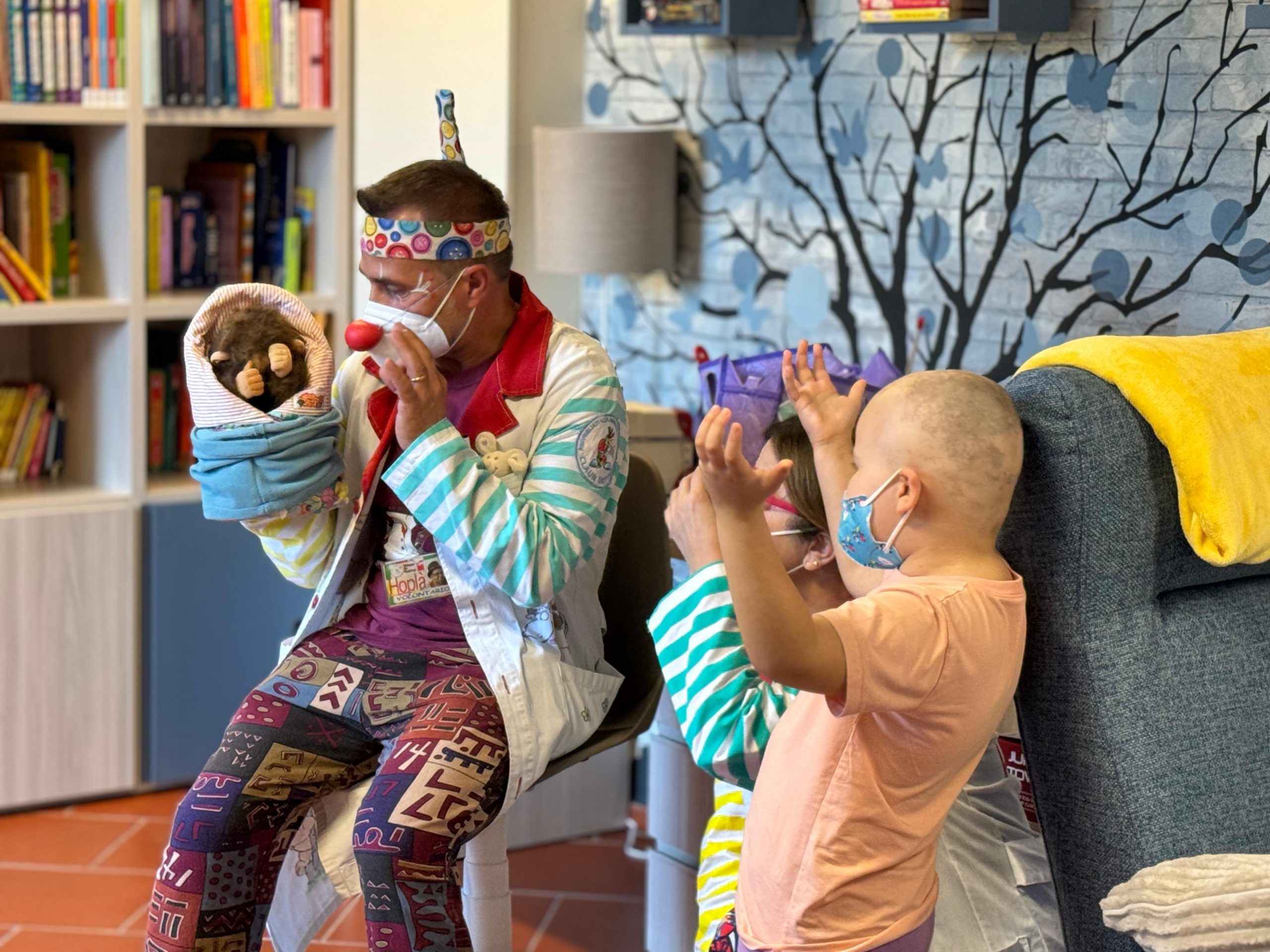 Clown di corsia che coinvolgono una bambina in un momento di gioco in ospedale